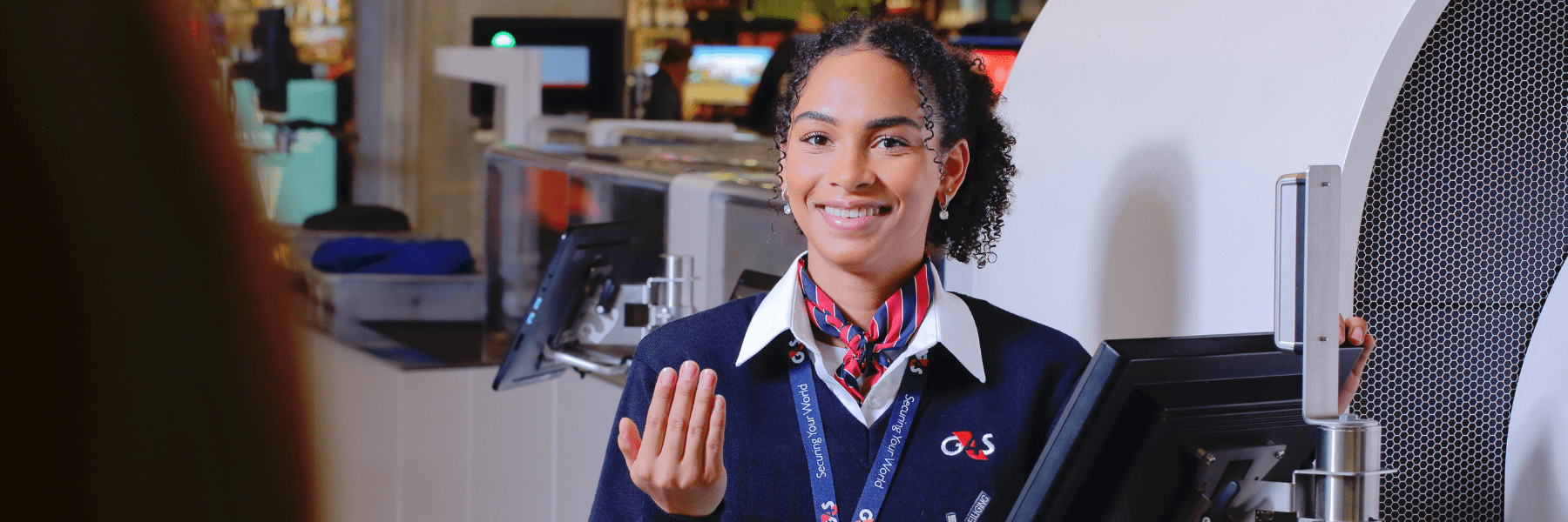Een vrolijke vrouw die bij de security check staat en werkt in de beveiliging op Eindhoven Airport